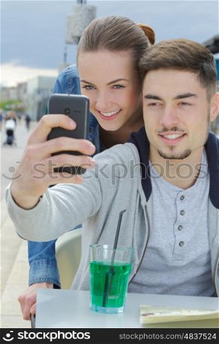young couple doing a selfie at bar terrace
