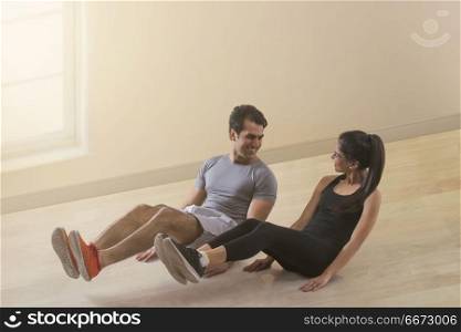Young couple doing exercise on floor
