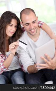 Young couple doing online shopping using electronic tablet