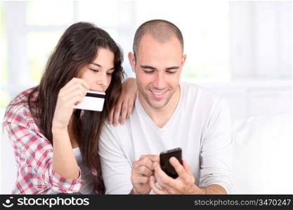 Young couple doing online shopping with smartphone