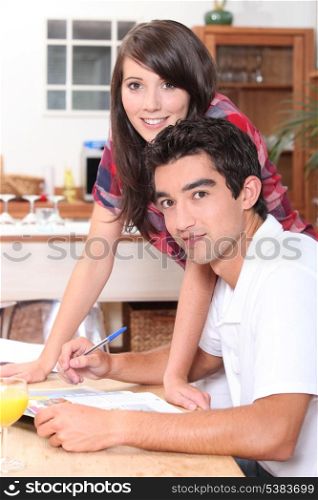 Young couple doing paperwork at the kitchen table
