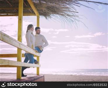 young couple drinking beer together at the beach. Couple Drinking Beer Together in empty beach bar during autumn time colored filter