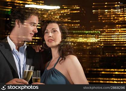 Young Couple Drinking Champagne Against Night Skyline Close-up