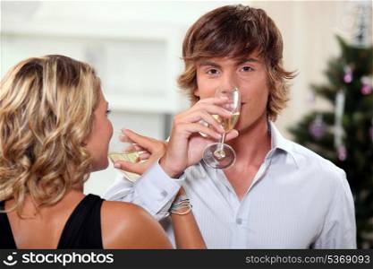 Young couple drinking champagne at Christmas