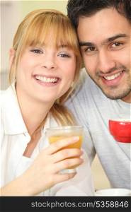 Young couple drinking orange juice and coffee