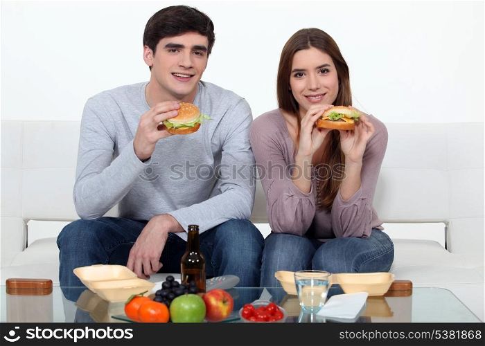 Young couple eating hamburgers