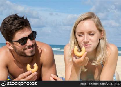 young couple eating on the beach
