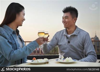 Young couple eating on the roof top, toast
