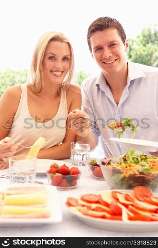 Young couple eating outdoors