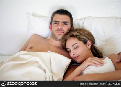 Young couple embraced in bed