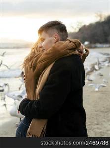 young couple embracing beach winter