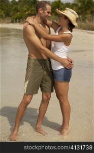 Young couple embracing each other on the beach