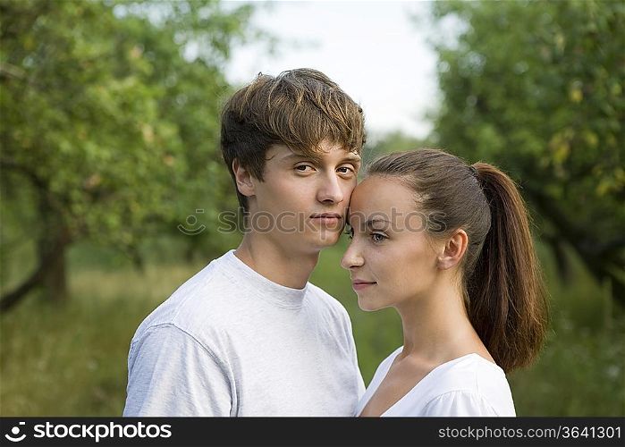 Young couple embracing in orchard