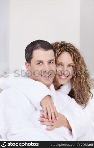 Young couple embracing in robes