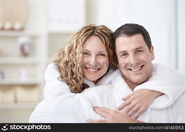 Young couple embracing in robes at home