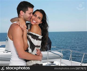Young couple embracing on yacht man kissing woman