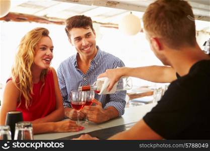 Young Couple Enjoying Drink At Outdoor Bar