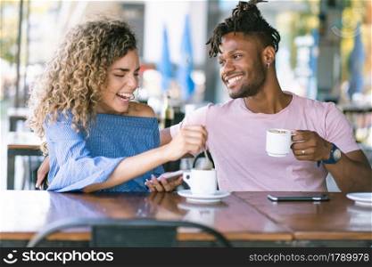 Young couple enjoying together while drinking a cup of coffee at a coffee shop.