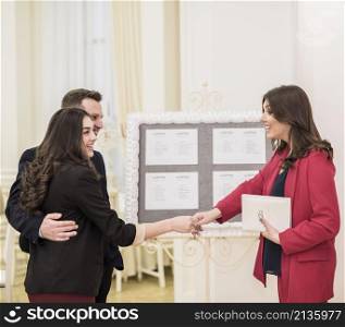 young couple event manager shaking hands
