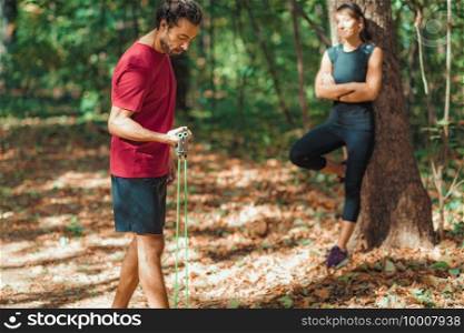 Young Couple Exercising with Elastic Resistance Band Outdoors in the Park. Young Couple Exercising with Elastic Resistance Bands  