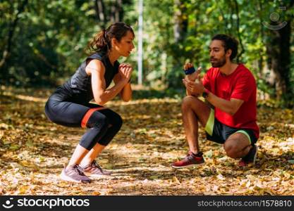 Young Couple Exercising with Elastic Resistance Band Outdoors in the Park. Young Couple Exercising with Elastic Resistance Bands