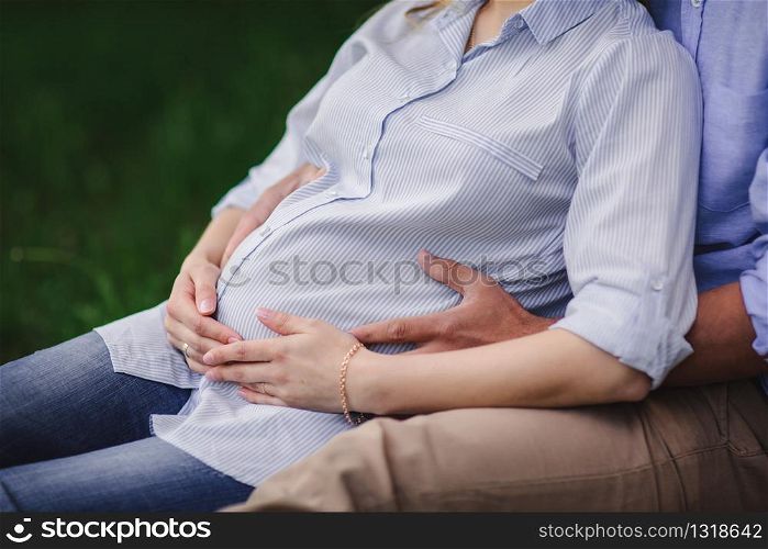 Young couple expecting baby hugging stomach. Young couple expecting baby hugging stomach. pregnancy and people concept