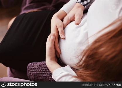 Young couple expecting baby hugging stomach. Young couple expecting baby hugging stomach. pregnancy and people concept
