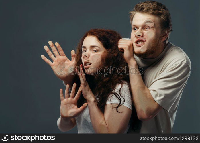 Young couple faces crushed on transparent glass, funny emotion. Man and woman with pressed grimaces standing at the showcase, humor, uncomfortable looking