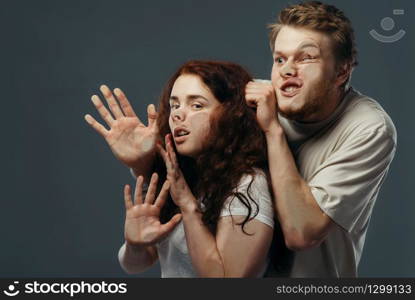 Young couple faces crushed on transparent glass, funny emotion. Man and woman with pressed grimaces standing at the showcase, humor, uncomfortable looking