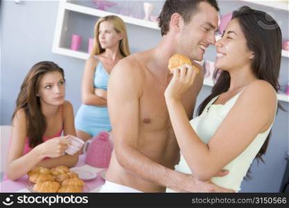 Young couple flirting in front of two young women