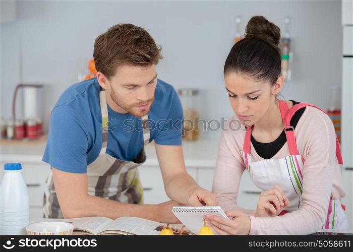 young couple following a recipe in a kitchen