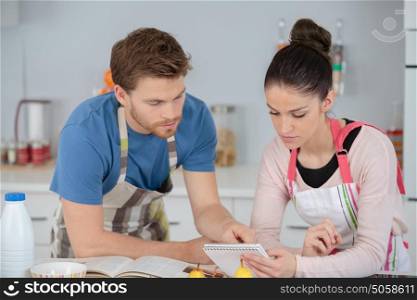 young couple following a recipe in a kitchen