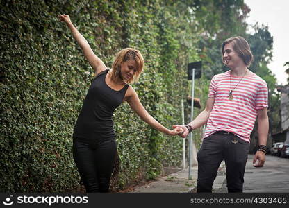 Young couple fooling around on suburban street