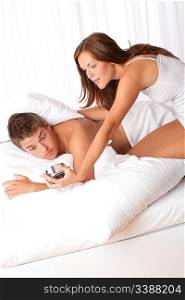Young couple getting up in the morning, woman holding alarm clock