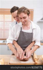 Young couple go to the kitchen and learn how to bake cookies online. Do it and play happily and have fun.