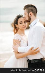 young couple groom with the bride on a sandy beach at a wedding walk