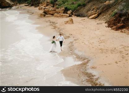 young couple groom with the bride on a sandy beach at a wedding walk