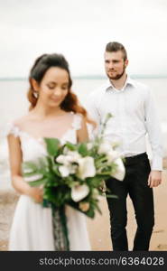 young couple groom with the bride on a sandy beach at a wedding walk