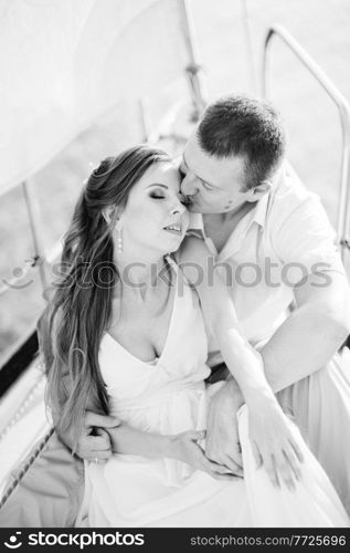 young couple guy and girl on a white sailing yacht