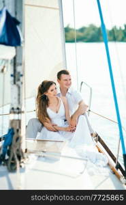 young couple guy and girl on a white sailing yacht