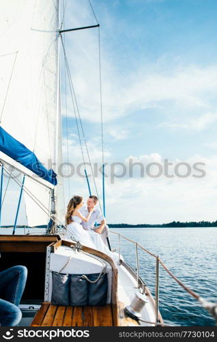 young couple guy and girl on a white sailing yacht