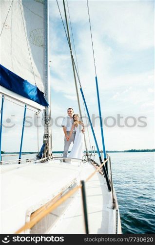 young couple guy and girl on a white sailing yacht