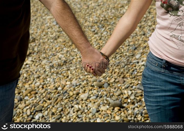 Young couple hands detail at the beach