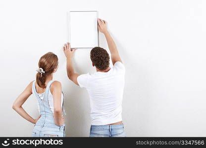 Young couple hangs framed on the wall