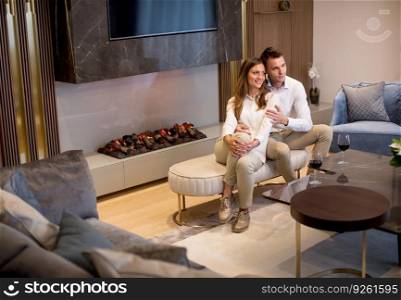 Young couple having a romantic evening with a glass of red wine at home in the luxury contemporary living room