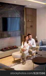 Young couple having a romantic evening with a glass of red wine at home in the luxury contemporary living room