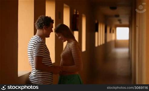 Young couple having a romantic talk, then their son running up and all of them embracing