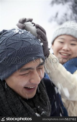 Young Couple Having a Snowball Fight