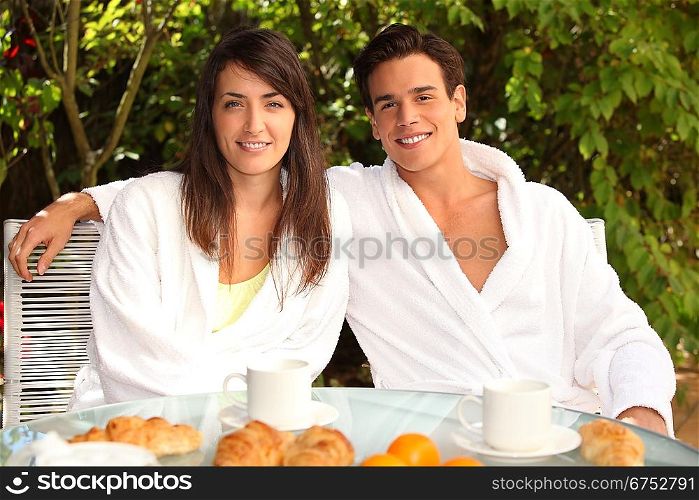 Young couple having breakfast outside
