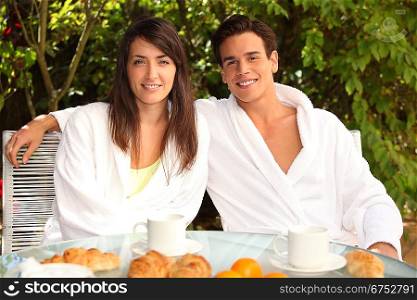 Young couple having breakfast outside